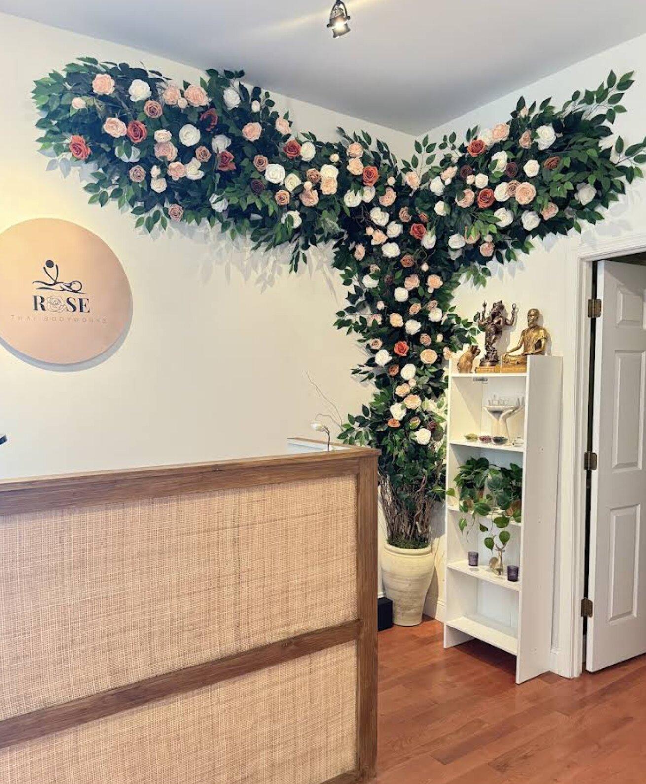 Front desk with Rose Thai Bodyworks logo and floral display